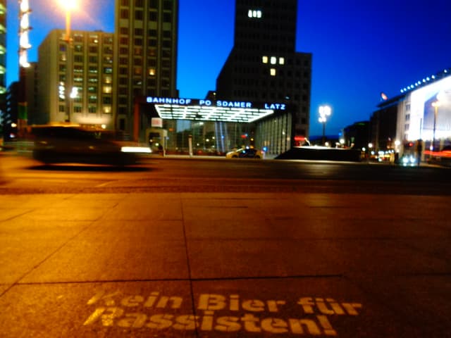 Kein Bier für Rassisten Street Stencil am Potsdamer Platz bei Nacht